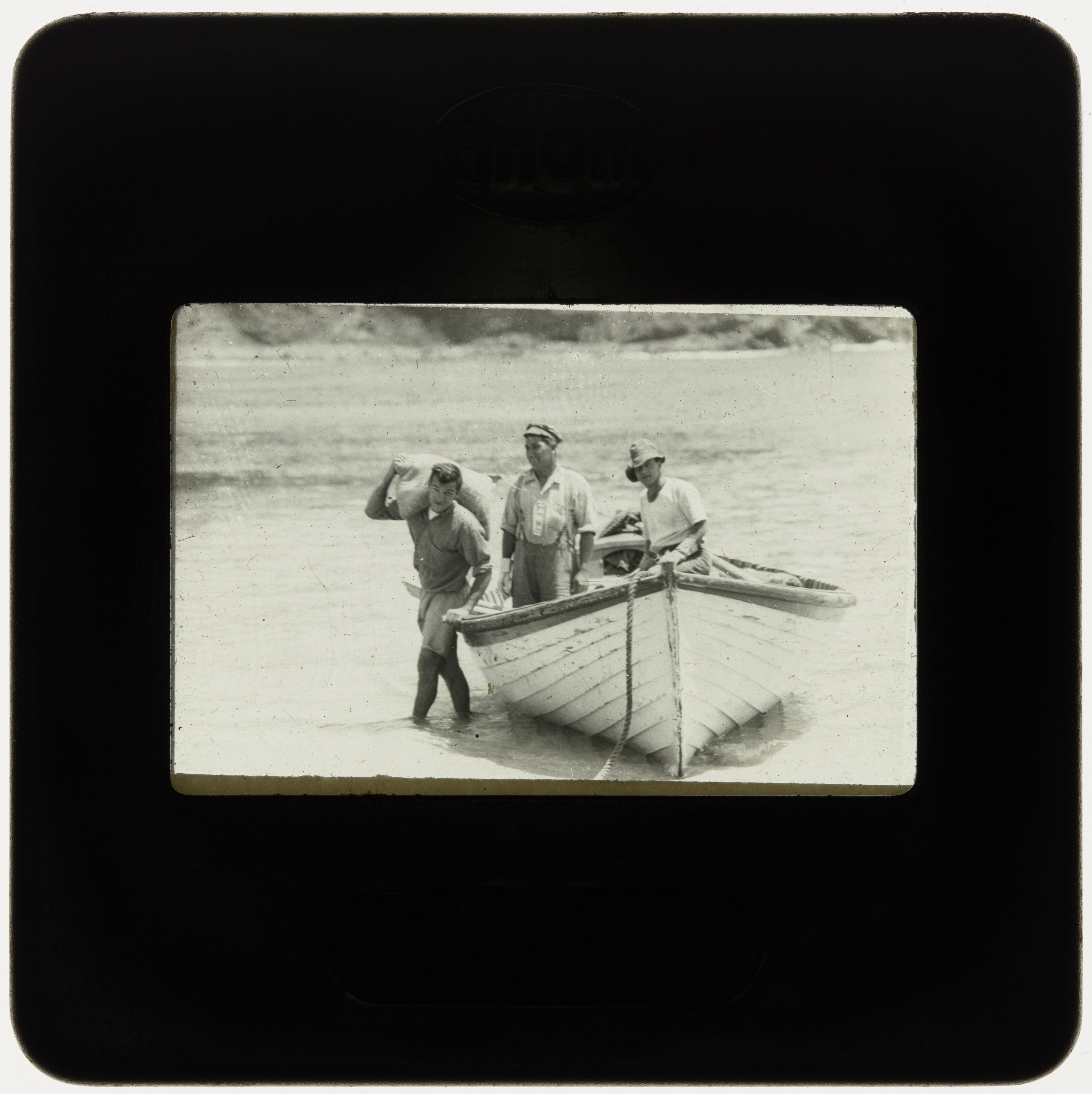 Three people with rowboat pulled ashore, Lord Howe Island