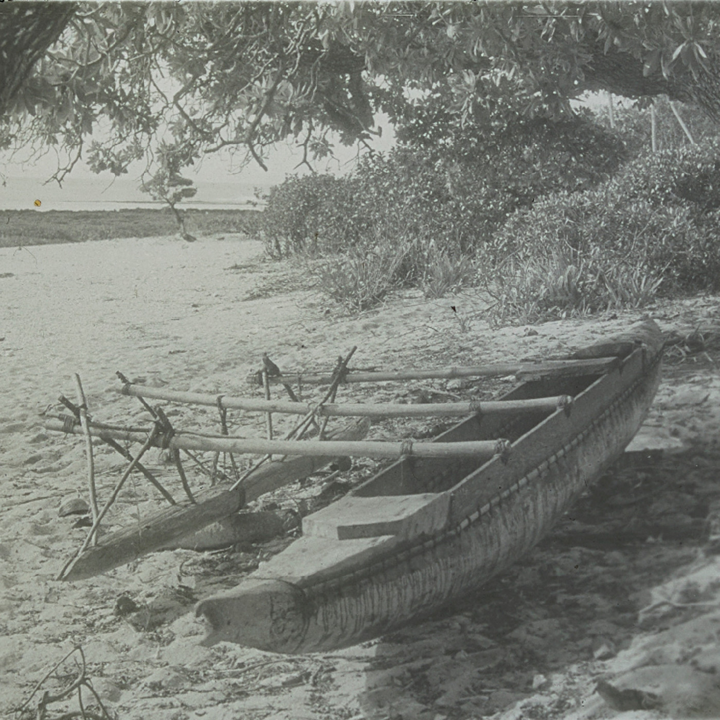 Wooden outrigger canoe on sandy shore of Eua, Tonga
