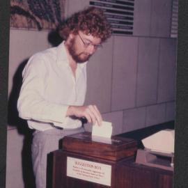Student contributing to suggestion box, Fisher Library, 1977