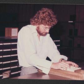 Student going through a drawer from the Library card catalogue, 1977