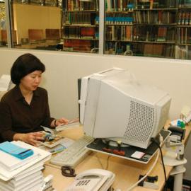 Library staff member processing books, Fisher Library, 2002