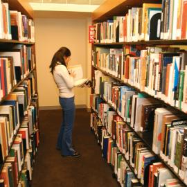 Student browsing book selves, Schaeffer Fine Arts Library, 2002