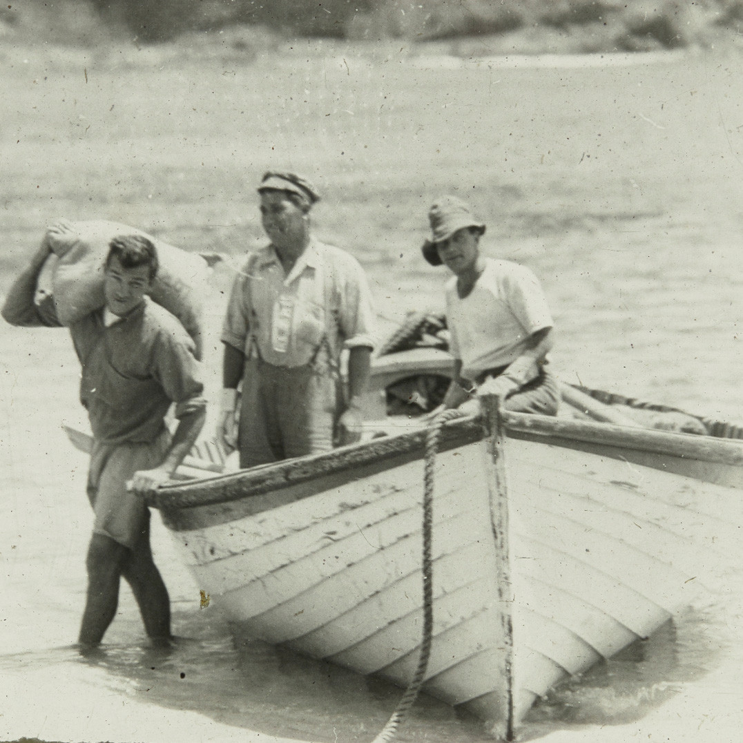 Three people with rowboat pulled ashore, Lord Howe Island